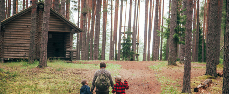 A father and his two sons, walking towards a cabin