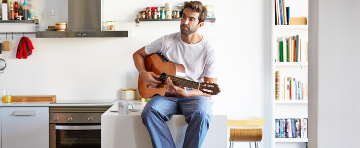 guitarist sitting on his kitchen countertop