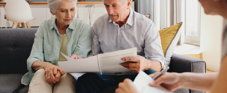 Elderly couple reading an estate plan with their lawyer