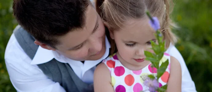 Chris Tymchuck and her toddler daughter in a lush field