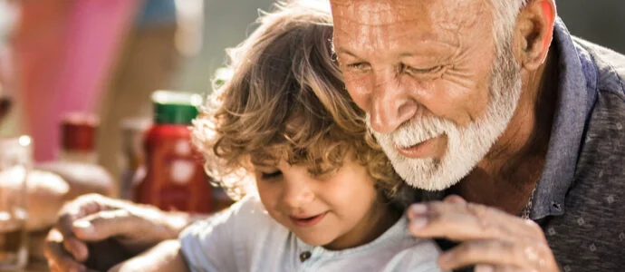 Grandparent with grandson on his lap petting a dog