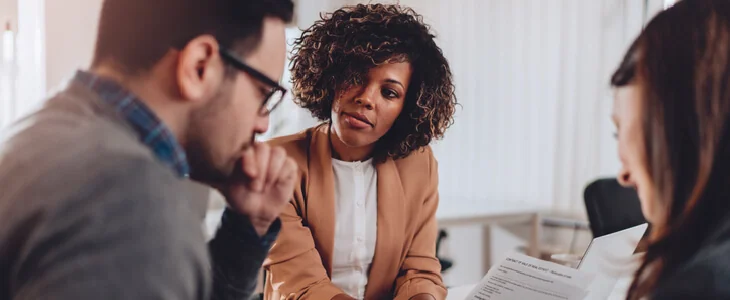 man and woman looking down at a document, with a female lawyer supervising